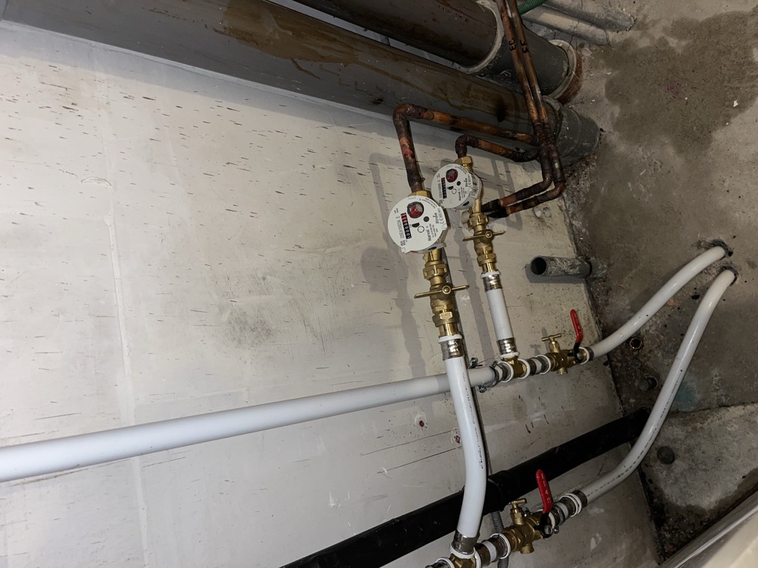 Compteurs d'eau et tuyaux en cuivre lors d'une réparation de fuite d'eau par un plombier d'urgence à Dijon